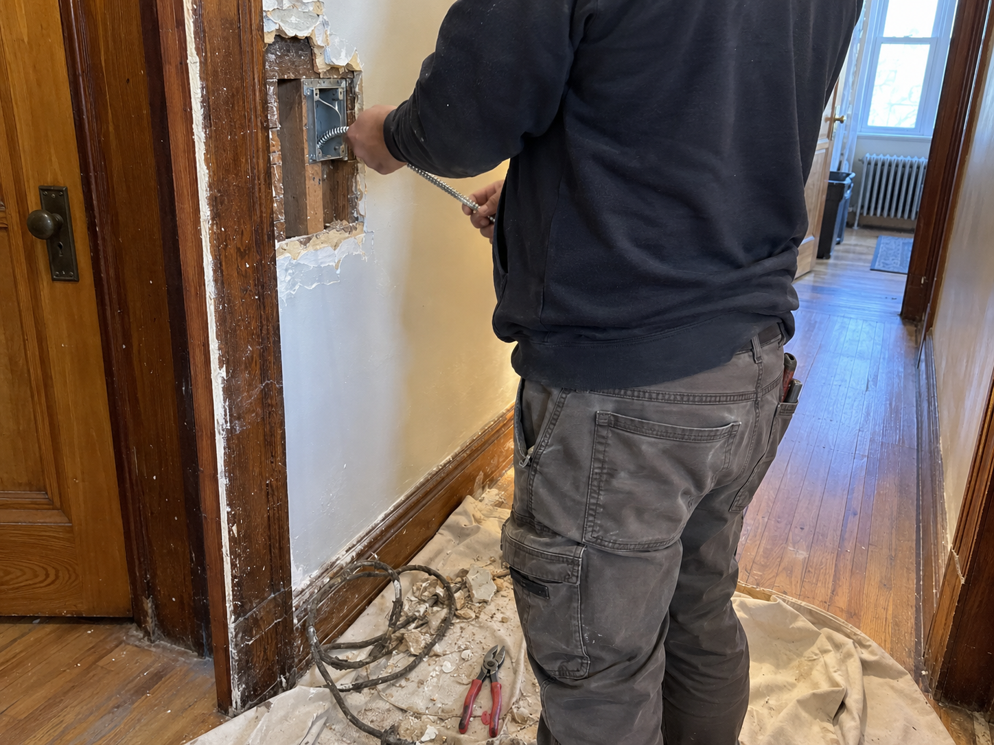 Electrician replacing old wiring in an attached Corona home