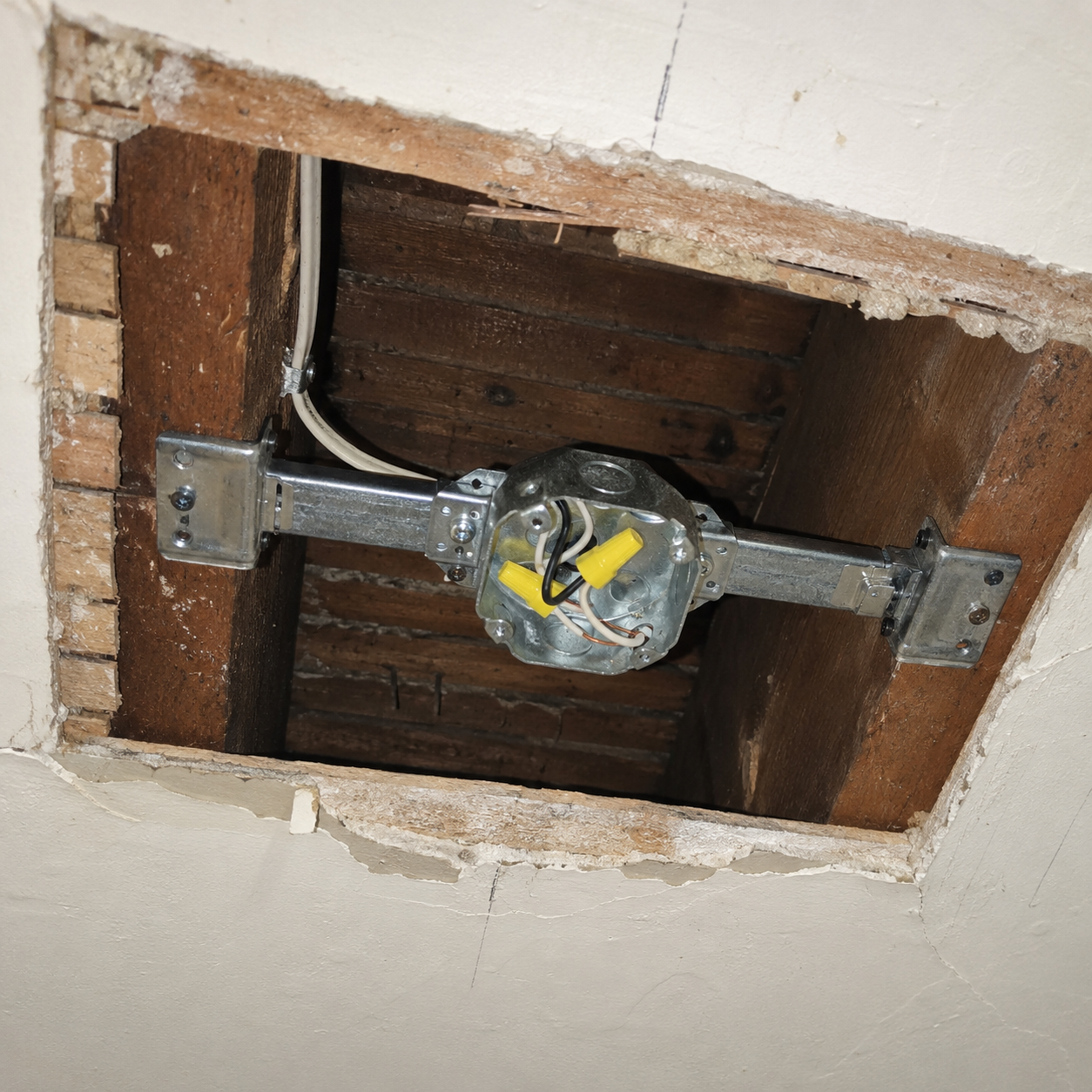 Fan-rated ceiling box and brace installed in a plaster ceiling