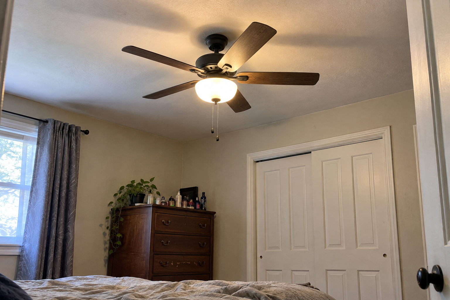 Ceiling fan with light kit installed in a Queens bedroom
