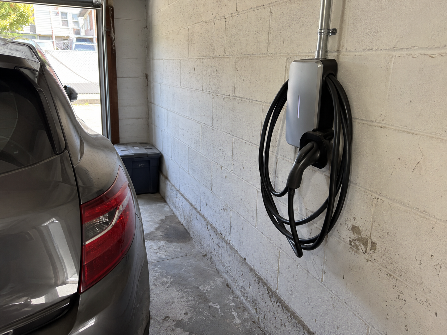 Level 2 EV charger mounted on a garage wall in Queens